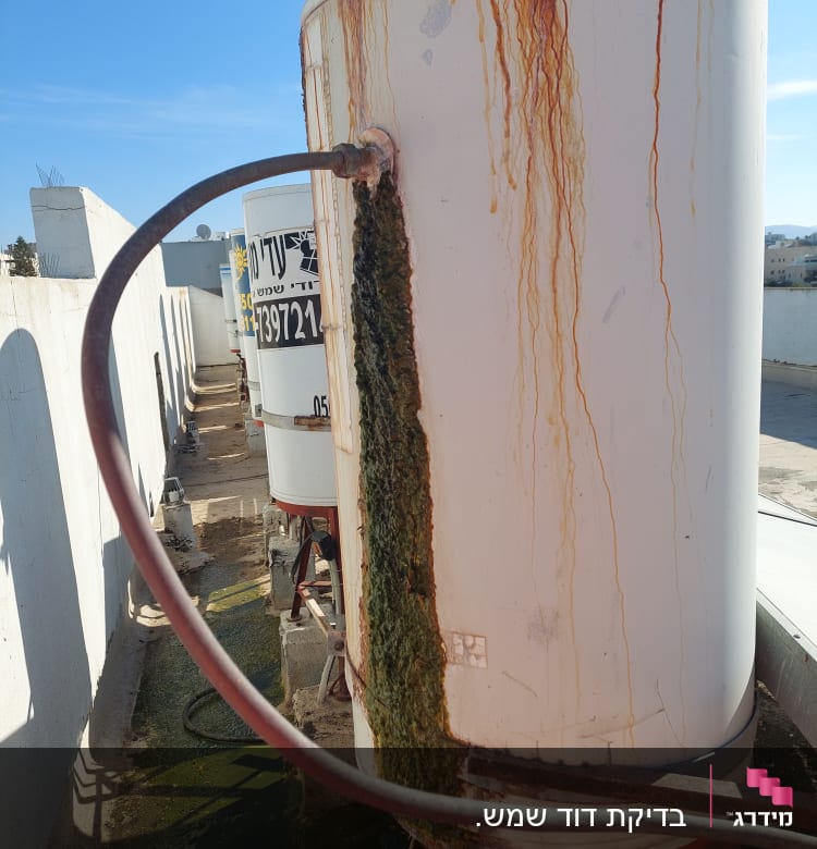 דוד שמש חלוד עם צינור ומים ירוקים